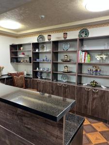 una cocina con encimera y estanterías con platos en Caravan Castle Boutique Hotel, en Bukhara