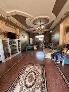 Caravan Castle Boutique Hotel في بوكسورو: غرفة معيشة كبيرة مع أشخاص يجلسون على الأريكة