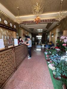 a man standing at a counter in a restaurant at Caravan Castle Boutique Hotel in Bukhara