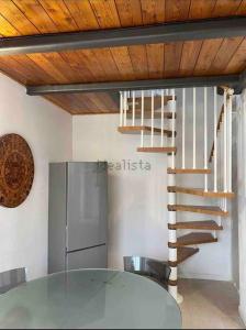 a kitchen with a glass table and a spiral staircase at Lilly’s Apartment Firenze in Florence