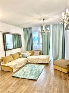 sala de estar con sofá y lámpara de araña en City View, en Bucarest