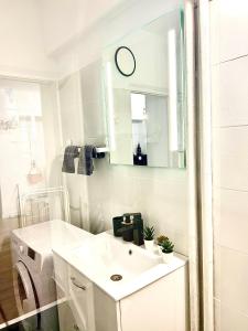 ein weißes Badezimmer mit einem Waschbecken und einer Waschmaschine in der Unterkunft City View in Bukarest