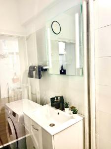 a white bathroom with a sink and a washing machine at City View in Bucharest +15 photos