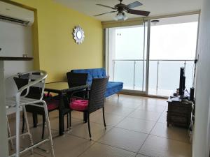 a living room with a table and chairs and a couch at PH El Palmar Residences 2203 in San Carlos