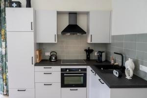 een keuken met witte kasten en een fornuis met oven bij 5 persons Holiday Home Comfort in Roelofarendsveen