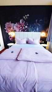 コーバン・ゴンドルフにあるLandgasthaus Zur Kupferkanneのベッドルーム1室(花が飾られた壁の白い大型ベッド1台付)