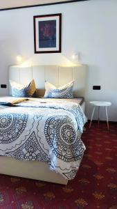 ein Schlafzimmer mit einem Bett mit einer weißen Tagesdecke in der Unterkunft Landgasthaus Zur Kupferkanne in Kobern-Gondorf