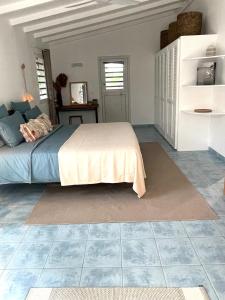 a bedroom with a bed and a tiled floor at Le Bungalow in Saint Barthelemy