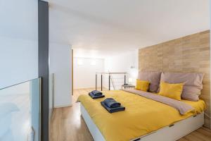 a bedroom with a large bed with yellow sheets at Venus Apartments - City Park II in Budapest