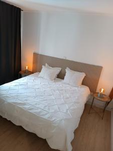 a bedroom with a large white bed with two lamps at Apartamento Playa Las Americas in Playa de las Americas