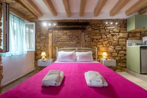 a bedroom with a large pink bed with two pillows at Venetian Sterna Casa in Corfu Town