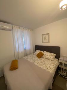um quarto com uma cama com duas almofadas e uma janela em Lovely Suite em Sibenik