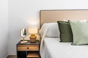 een slaapkamer met een bed en een bijzettafel met een spiegel bij Apartamento Dora Maar I in Marbella