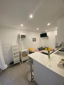 a kitchen and living room with a white counter and a room at Lovely Suite in Šibenik