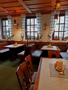 a restaurant with tables and chairs and windows at Landgasthaus Zur Kupferkanne in Kobern-Gondorf
