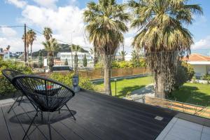 a deck with a chair and palm trees at Faliro Hotel in Faliraki