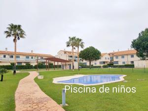 a park with a swimming pool and palm trees at Panoramica Golf Karilo in Sant Jordi