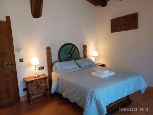 1 dormitorio con 1 cama con sábanas azules y 2 lámparas en Casa Rural Ubaba, en Artaza