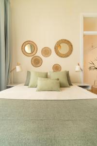 a bedroom with a white bed with mirrors on the wall at Alcácer House in Alcácer do Sal