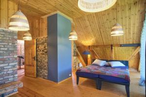 ein Schlafzimmer mit einem Bett in einem Zimmer mit Holzwänden in der Unterkunft Ugunu Dambji in Talsi