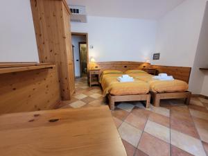 una fila di letti in una camera con pareti in legno di RAINBOW a Rovereto