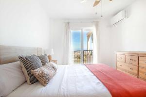 a white bedroom with a large bed and a window at Ap. con vistas panorámicas in Benalmádena