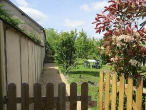 een houten hek naast een tuin met een picknicktafel bij Gîte village des bords de Loire in Montjean-sur-Loire