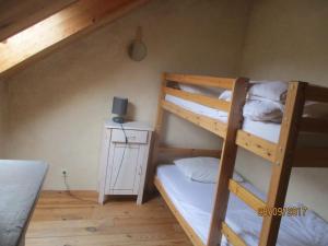 Zimmer mit Etagenbett, 2 Etagenbetten und einem Tisch in der Unterkunft Gîte village des bords de Loire in Montjean-sur-Loire