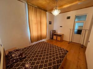 a bedroom with a bed and a window and a chandelier at House in the village - APPLE PARADISE in Gabala
