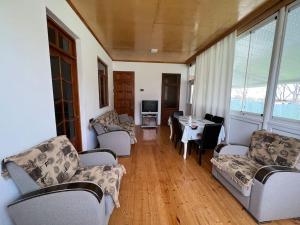 a living room with couches and a table and chairs at House in the village - APPLE PARADISE in Gabala