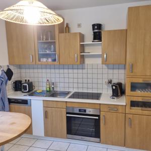 eine Küche mit Holzschränken und einer Spüle in der Unterkunft 25 Schützenstraße in Diekholzen + 6 Fotos
