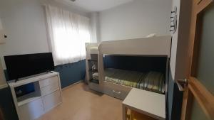 a small room with a bunk bed and a television at El Faro de Canet in Canet de Berenguer