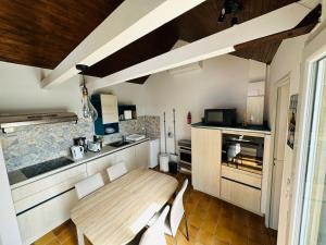eine Küche mit einem Holztisch und einer Theke in der Unterkunft Les Gîtes De La Caneda in Sarlat-la-Canéda