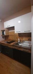 a kitchen with white cabinets and a stove at U Wojtaszka in Mizerna