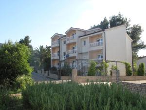 an apartment building with a fence in front of it at Apartments Mia in Stari Grad