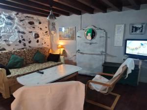 sala de estar con sofá y TV en Atardecer en Gredos 1, en San Bartolomé de Tormes