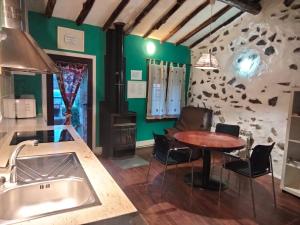 a kitchen with a sink and a table with chairs at Atardecer en Gredos 1 in San Bartolomé de Tormes