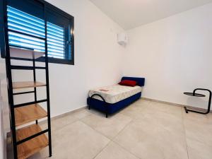 um pequeno quarto com um beliche e uma escada em Luxury Penthouse 5 Rooms em Or Yehuda