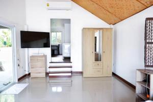 a living room with a television and a door at Kingsacre in Nai Yang Beach