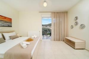 a bedroom with a large bed and a balcony at Nik-Ntin Villa Deluxe in Prinos