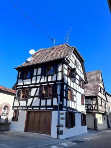 a black and white building with a garage at Bien dans vos Schlopps in Dambach-la-Ville