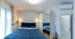 ein Schlafzimmer mit einem blauen Bett und einem Spiegel in der Unterkunft Sofia Apartment with Free Parking in Sofia