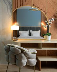 a bedroom with a bed and a chair and a mirror at Hotel Brilant Saranda in Sarandë