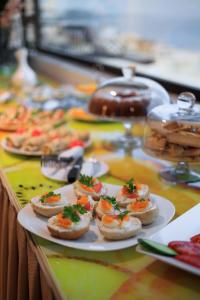 una mesa cubierta con platos de comida en una mesa en Hotel Brilant Saranda, en Sarandë