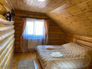 sypialnia z łóżkiem w drewnianym domku w obiekcie Smerekovyi Dvir w mieście Polyana (Polana)
