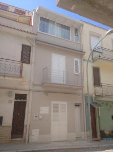 a large white house with balconies on a street at Casa vacanze Venere in Balestrate