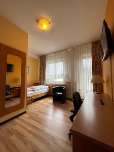 ein Hotelzimmer mit einem Schlafzimmer mit einem Bett und einem Schreibtisch in der Unterkunft Hotel Kull von Schmidsfelden in Bad Herrenalb