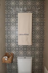 a bathroom with a toilet and a tiled wall at Casa das Rosas by Homing in Arco da Calheta