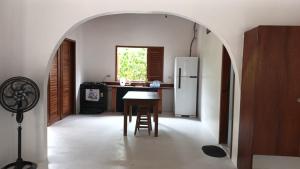 an archway in a kitchen with a table and a refrigerator at Casa Serena in Atins