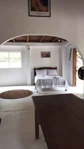 a white bedroom with a bed and a table at Casa Serena in Atins